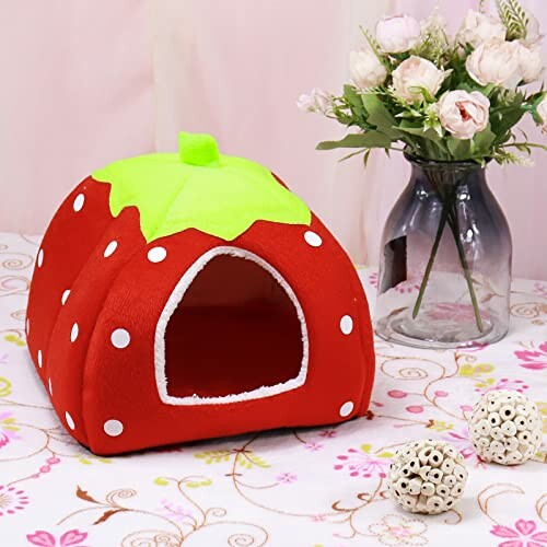 Strawberry-shaped pet house with vase of roses